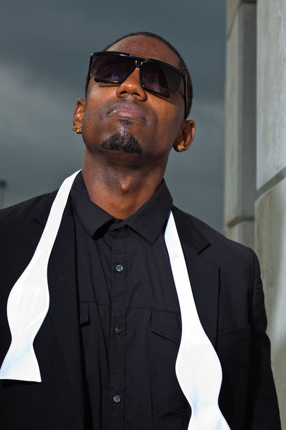 Cool black american man in dark suit wearing sunglasses. Fashion shot in urban setting. - Foto, Imagem