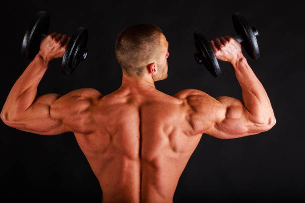 Bodybuilder with relief muscular body and dumbbells - Фото, зображення