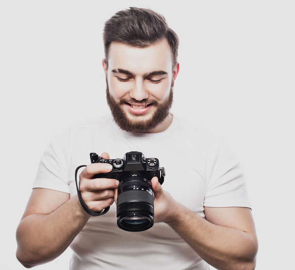 young bearded photographer taking pictures with digital camera. - Zdjęcie, obraz