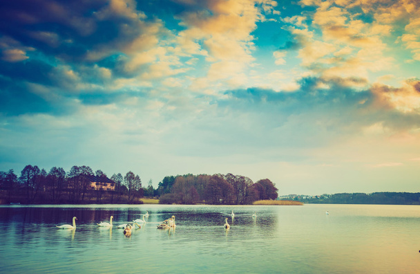 Vuosikerta kuva auringonlaskusta rauhallisella järvellä
 - Valokuva, kuva