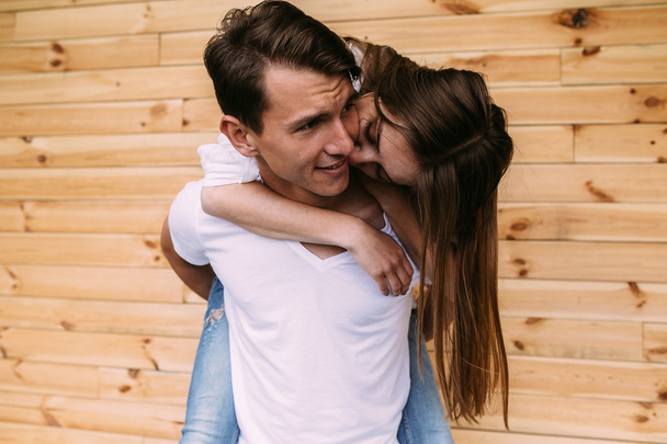 couple posing on a background of the wooden wall - Фото, изображение