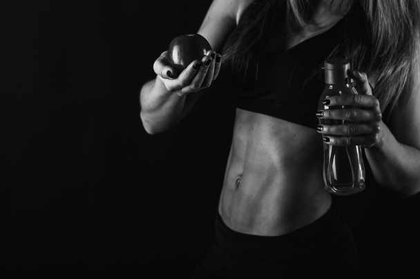 Sexy fitness woman on a dark background. - Фото, изображение
