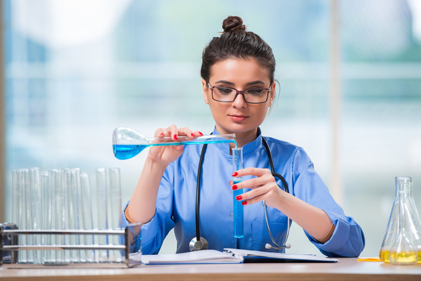 Женщина-врач проводит химические тесты в лаборатории - Фото, изображение