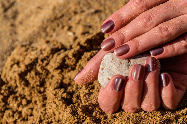 Krásná, udržovaná ženské ruce s manikúrou na písku - Fotografie, Obrázek