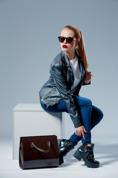 Fashion model on white cube smiling up in sunglasses - Valokuva, kuva