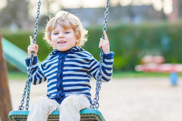 αξιολάτρευτο μικρό παιδί αγόρι διασκεδάζοντας αλυσίδα swing για υπαίθρια Playground αθλήματα αναψυχής - Φωτογραφία, εικόνα