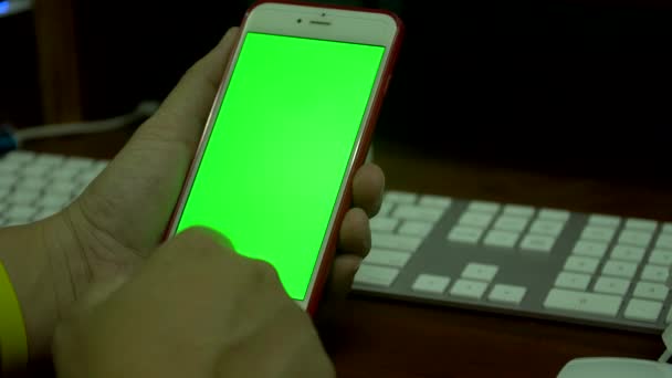 Mano femenina usando un teléfono inteligente con una pantalla verde
 - Metraje, vídeo