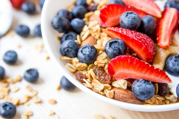 Healthy breakfast concept. Granola with blueberries and strawberries in the white bowl. - Foto, afbeelding