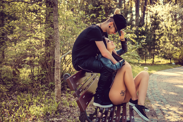 Jovem casal casual relaxante em um banco
 - Foto, Imagem