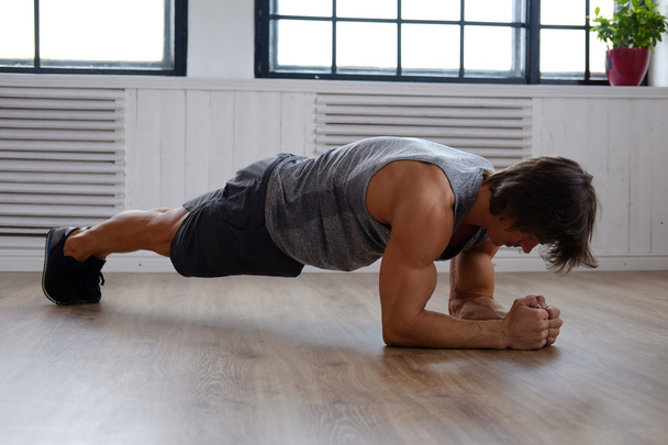 Homme faisant de l'exercice de l'estomac sur un plancher
 - Photo, image