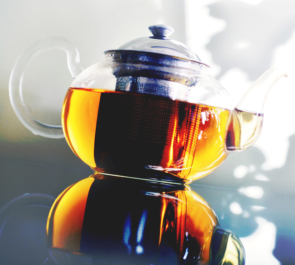 Glass teapot standing on a glass table. - Photo, image