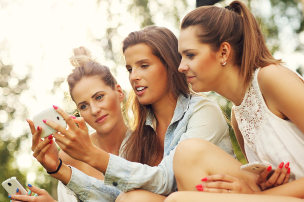 Girlfriends using smartphones - Foto, imagen