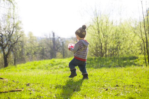 Ένα παιδί που παίζει με ένα Frisbee σε εξωτερικούς χώρους. - Φωτογραφία, εικόνα