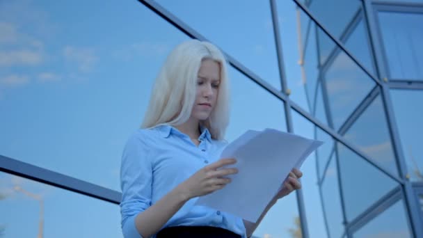 blonde businesswoman throwing documents - Materiał filmowy, wideo