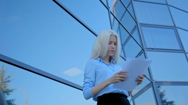 blonde businesswoman throwing documents - Materiał filmowy, wideo