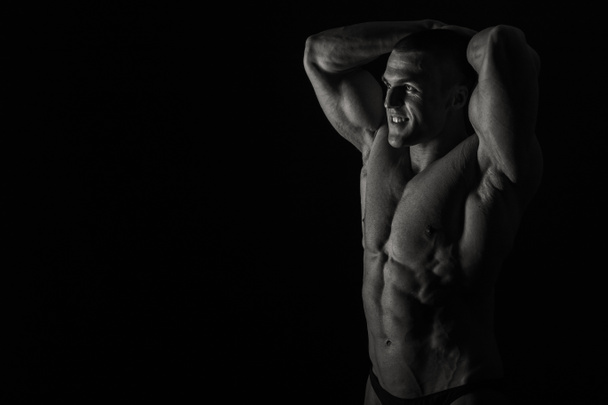 Cuerpo masculino elegante y musculoso sobre fondo negro
 - Foto, imagen