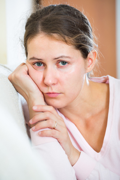 upset woman sitting in domestic interior  - Foto, Imagem