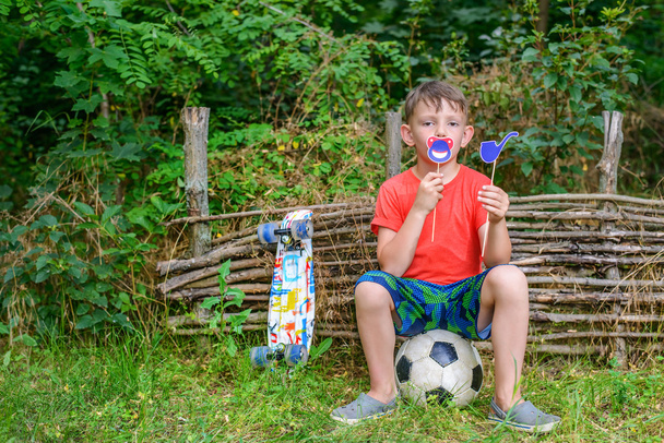 Boy holding toy pipe and joking symbols near mouth - Photo, Image