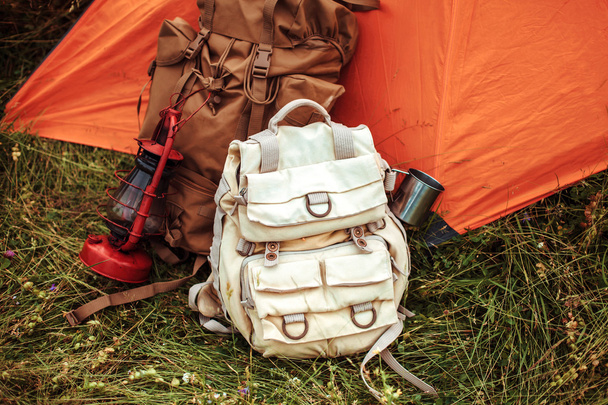the tent and two backpacks near a tourist track in mountains on green grass - 写真・画像