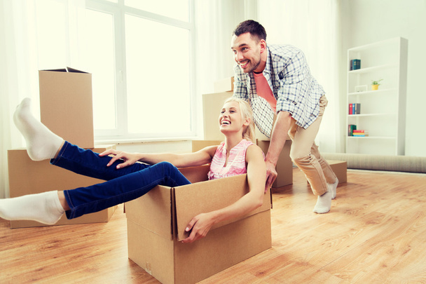 couple with cardboard boxes having fun at new home - Photo, Image