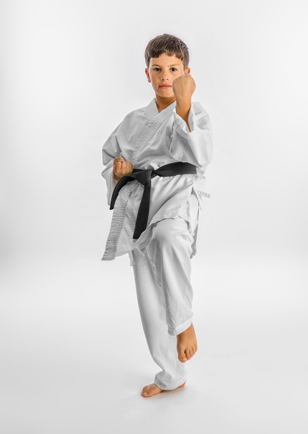 Boy in white kimono during training karate kata exercises - Foto, Bild