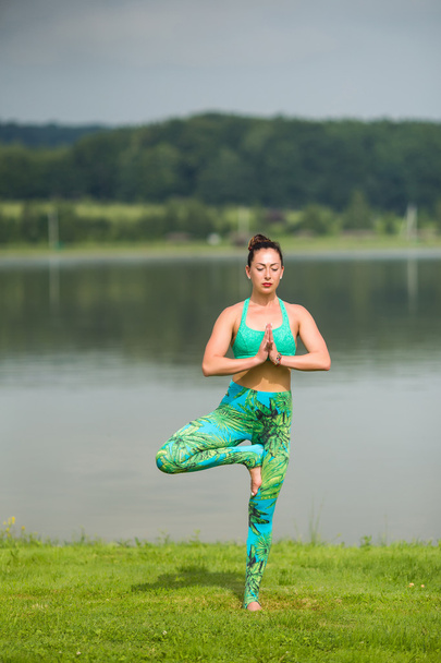 Yoga girl formación al aire libre sobre fondo de la naturaleza. Concepto de yoga
. - Foto, Imagen