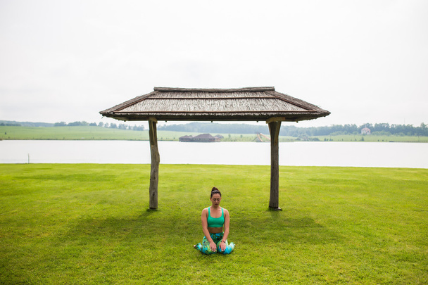 Yoga-Mädchen, die im Freien vor dem Hintergrund der Natur trainieren. Yoga-Konzept. - Foto, Bild