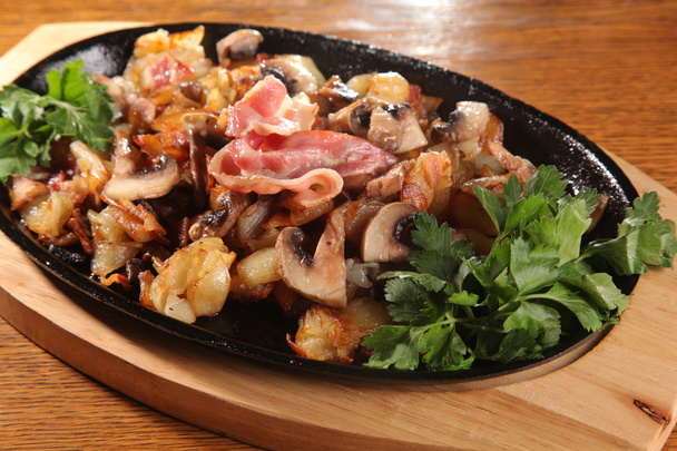 batatas fritas de panela preta com cogumelos e Bacon
 - Foto, Imagem
