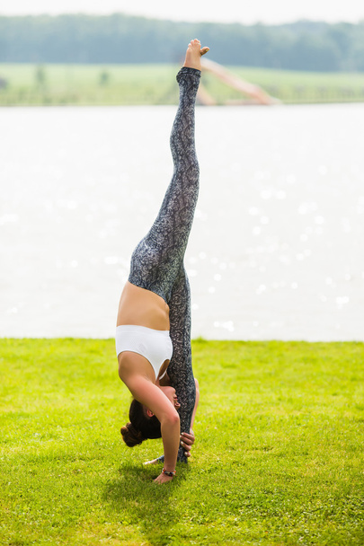 Yoga meisje opleiding buiten op natuur achtergrond. Yoga concept. - Foto, afbeelding