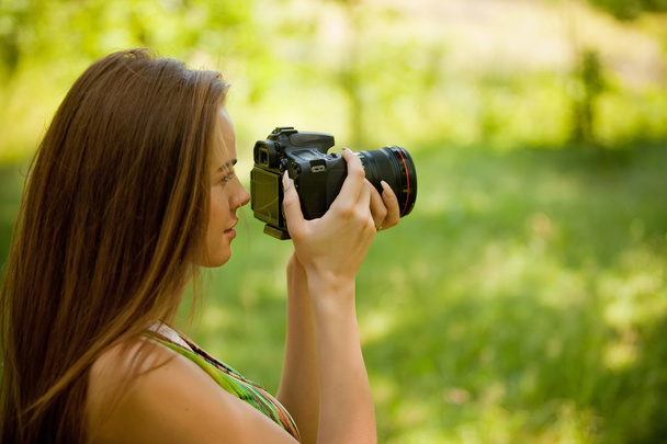 Κοπέλα που έβγαζε φωτογραφίες με μια φωτογραφική μηχανή στην φύση - Φωτογραφία, εικόνα