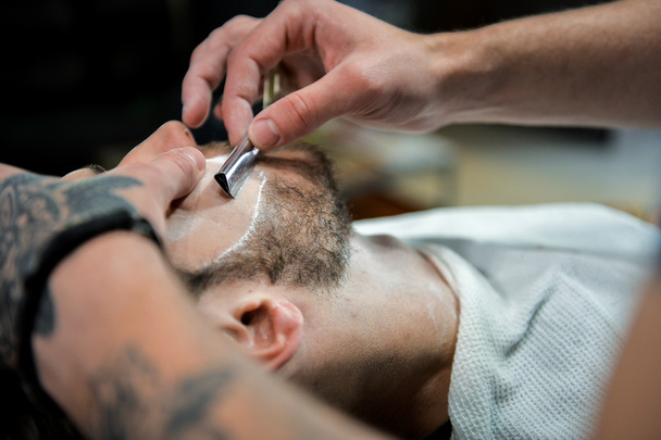 Парикмахер режет бородатого человека
. - Фото, изображение