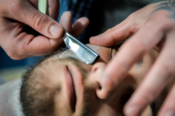 Le coiffeur coupe la barbe.
. - Photo, image