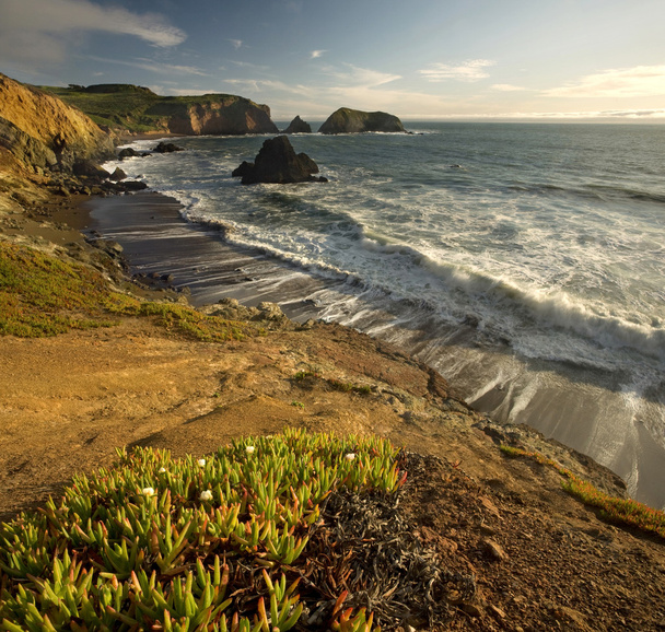 Sunset over Pacific Ocean and steep cliffs in California - Photo, Image
