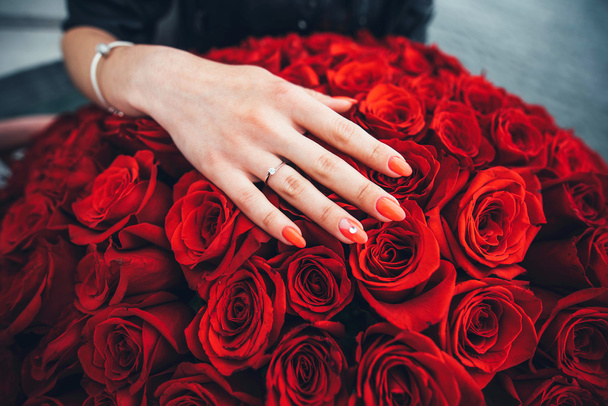 hand with diamond ring on the red roses - Φωτογραφία, εικόνα