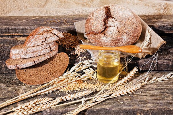 Žito celozrnný chléb na dřevěné desce s olivovým olejem - Fotografie, Obrázek