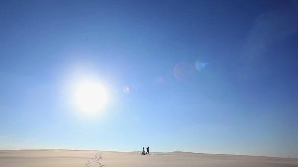 Romantic couple walking holding hands under sun. Two young lovers walking cheerful together on romance in summer.Maspalomas sand dunes, Gran Canaria, Canary Islands, Spain - Footage, Video