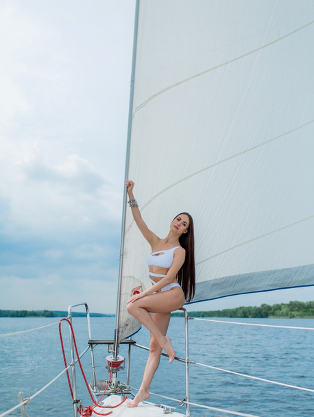 ヨットの上でスタイリッシュな水着の女性 - 写真・画像