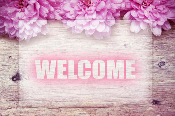 flores de color rosa en madera con palabra Bienvenido
 - Foto, imagen