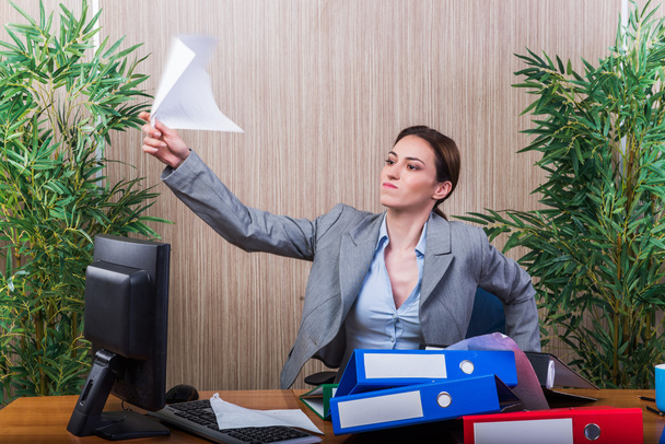 Mujer tirando papeles en la oficina bajo estrés
 - Foto, Imagen
