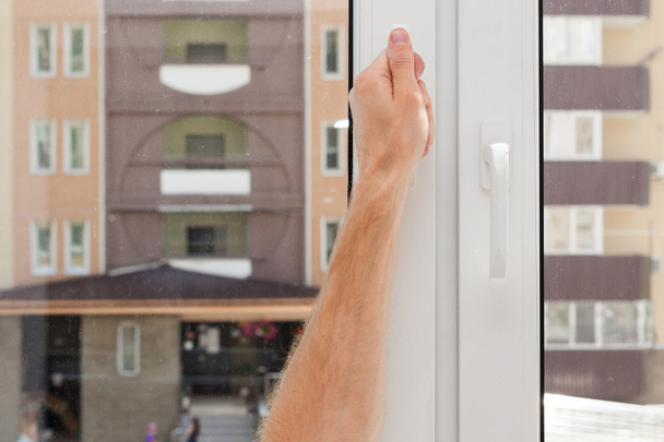 Ο άνθρωπος το χέρι ανοίγει ένα πλαστικό παράθυρο pvc - Φωτογραφία, εικόνα