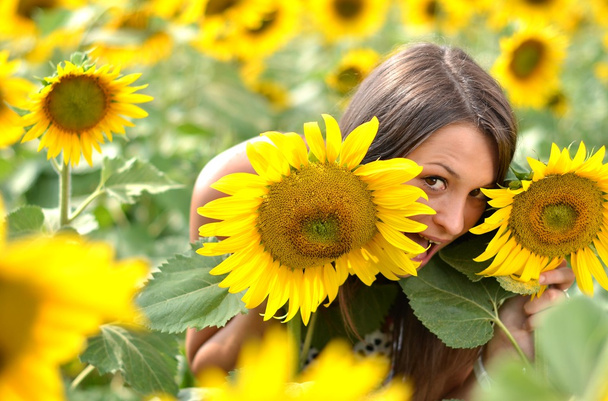 Portrait of young woman with sunflowers - Foto, immagini