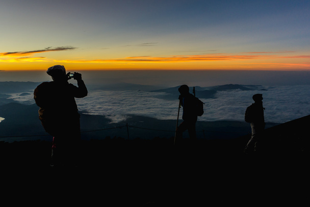 Wandelaars verzamelen tijdens zonsopgang op de top van Mt. Fuji. - Foto, afbeelding