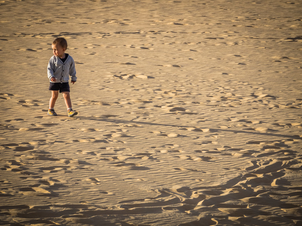 Menino caminhando nas dunas de areia
 - Foto, Imagem