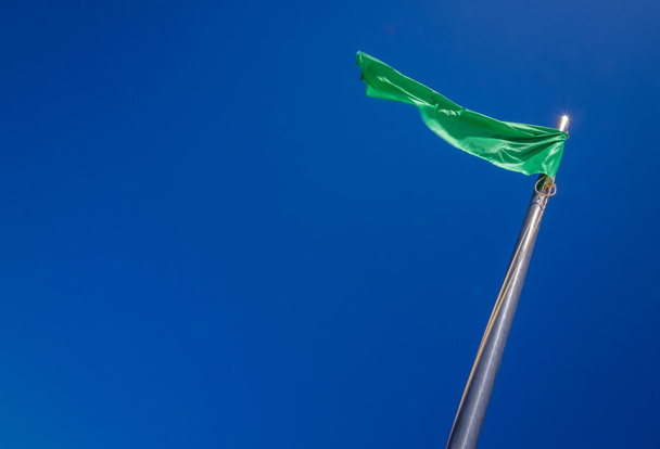 緑色の旗が風になびく - 写真・画像