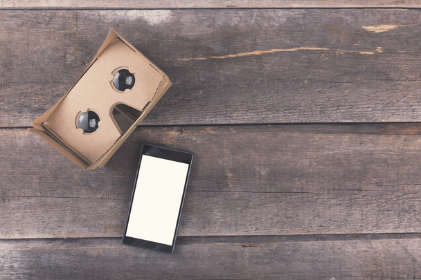 картонные очки виртуальной реальности с пустым смартфоном на дереве
 - Фото, изображение