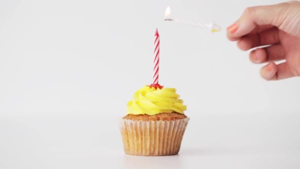 woman with lighting candle on birthday cupcake - Кадры, видео