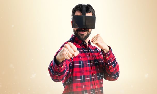 Man using VR glasses giving a punch - Фото, изображение