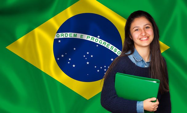 Estudante adolescente sorrindo sobre a bandeira brasileira
 - Foto, Imagem