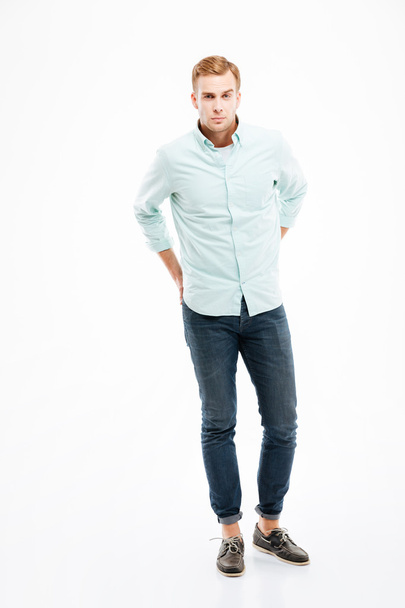 Man in jeans and shirt standing with hands behind back - Foto, Imagen
