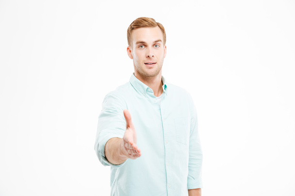 Attractive young businessman standing and giving his hand for handshake - Zdjęcie, obraz